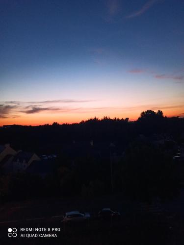 a sunset over a city with trees and cars at La pause bretonne in Quéven