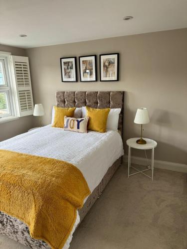 a bedroom with a large bed with yellow pillows at Brentford Guest Rooms in Brentford