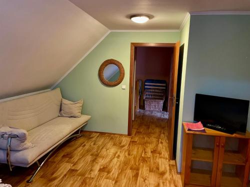 een woonkamer met een bank en een flatscreen-tv bij Dvoupodlažní zděná chata in Tábor