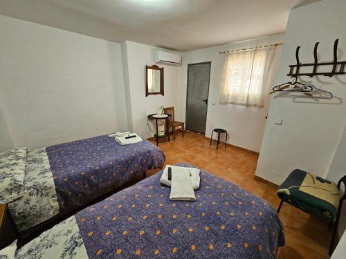 ein Hotelzimmer mit 2 Betten und einem Tisch in der Unterkunft Corralazo A in Calasparra