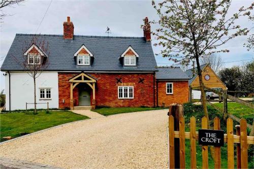 a red brick house with a sign in front of it at The Cabin at the Croft - Idyllic rural retreat perfect for couples and dogs in Leigh