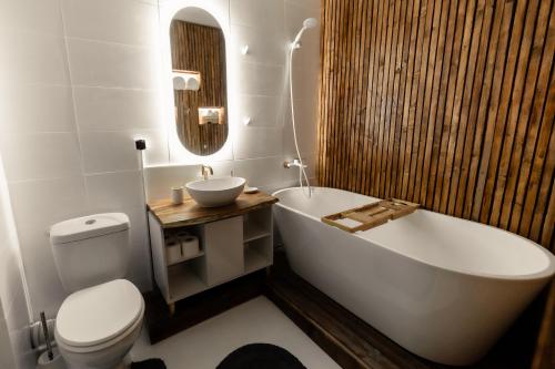 a bathroom with a tub and a toilet and a sink at Blue Harmony Apartment in Floreşti