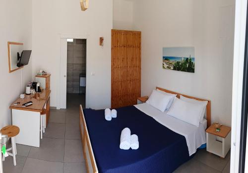 a bedroom with a bed with two white shoes on it at KipoRooms in Zollino