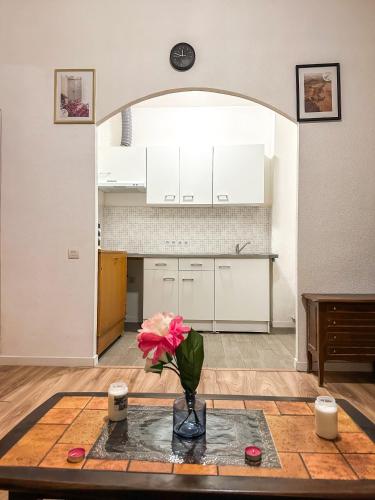 un vase avec une fleur sur une table dans une cuisine dans l'établissement Studio Cosy - Cœur Perpignan, à Perpignan