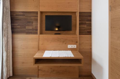 a room with a tv and a wooden wall at Superior Hotel Post Ischgl in Ischgl