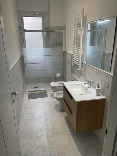 a bathroom with a sink and a toilet and a mirror at Ilaria San siro fiera Milan apartment in Milan