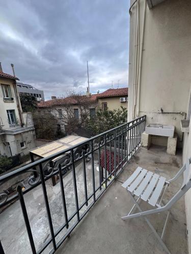 einem weißen Stuhl auf dem Balkon eines Gebäudes in der Unterkunft Studio Cosy - Cœur Perpignan in Perpignan