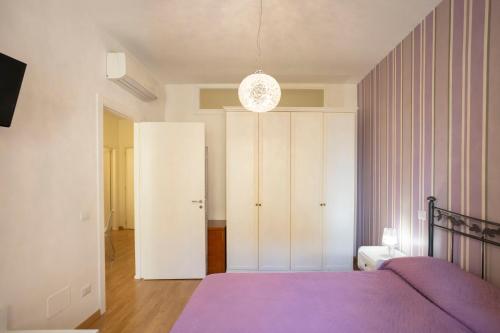 a bedroom with a purple bed and a white closet at Amalfi e Positano Home in Salerno