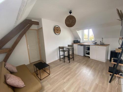 a living room with a couch and a kitchen at Appartement confort in Pacy-sur-Eure