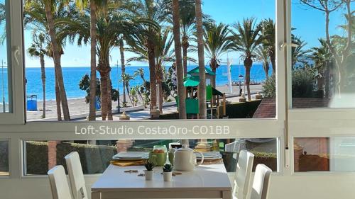 une salle à manger avec une table et une vue sur la plage dans l'établissement Primera línea playa Apart 1 Bed CostaOro-CO1BA DELUXE Seafront ó Loft-Studio CostaOro-CO1BB STANDARD, à Torrox Costa