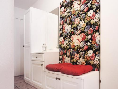 Habitación con cortina de flores y almohada roja en Fricks Appartement, en Dölsach
