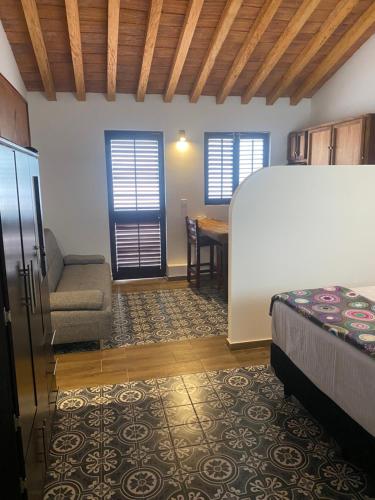 a bedroom with a bed and a table and a chair at Villa Serena Centro Historico in Mazatlán