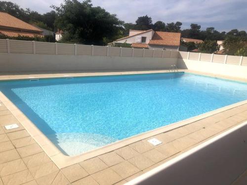 une grande piscine avec de l'eau bleue dans l'établissement Aurora Surf Lodge maison Mer, à Saint-Vincent-sur-Jard