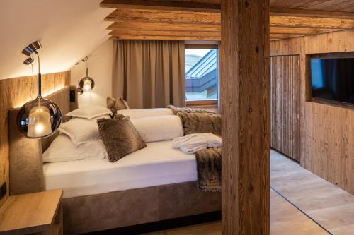 a bedroom with a large white bed with a window at Superior Hotel Post Ischgl in Ischgl