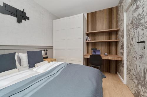 a bedroom with a large bed and a desk at Ekskluzywny apartament w Porcie Popowice - Fair Rentals in Wrocław