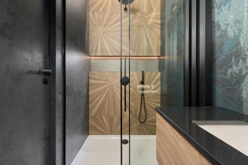 een douche met een glazen deur in de badkamer bij Ekskluzywny apartament w Porcie Popowice - Fair Rentals in Wrocław