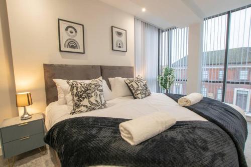 1 dormitorio con 1 cama grande y ventana grande en Luxury City Centre Apartment (Weekly Booking), en Hull