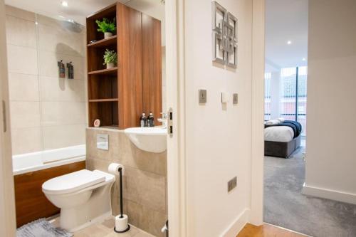 uma casa de banho com um WC, um lavatório e uma cama em Luxury City Centre Apartment (Weekly Booking) em Hull