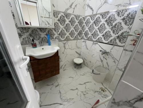 a bathroom with a sink and a shower with marble tiles at MET house in Hacılar