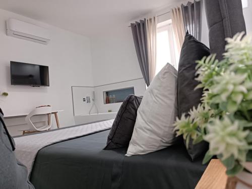 a bedroom with a black bed and a couch with pillows at Il Sogno di Giò in Alghero