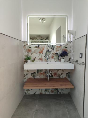 a bathroom with a sink and a mirror at Il Sogno di Giò in Alghero