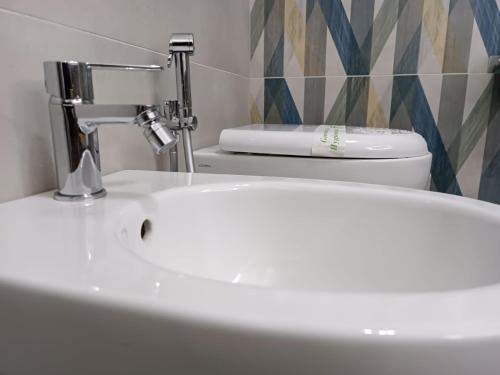 a bathroom with a white sink and a toilet at Il Sogno di Giò in Alghero