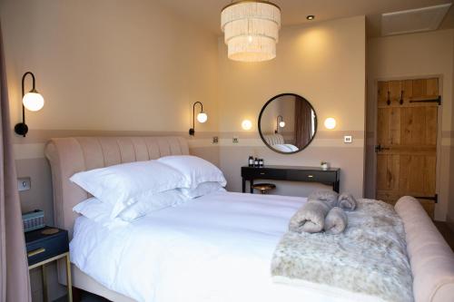 Un dormitorio con una cama blanca con dos animales de peluche. en TOFY (The Old Forge York), en York