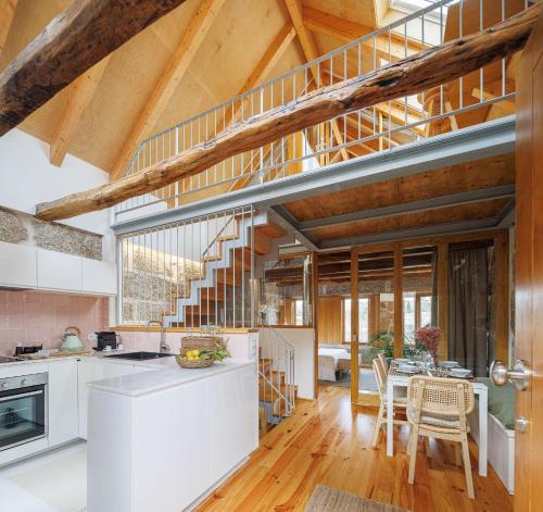 a kitchen and dining room with a staircase in a house at Casa da Corina in Amarante