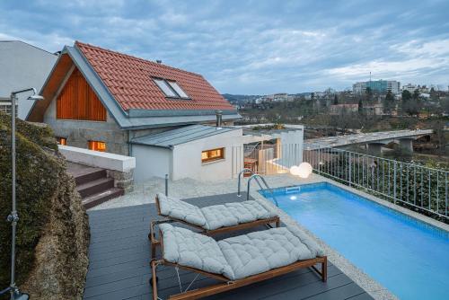 a house with a swimming pool on a balcony at Casa da Corina in Amarante