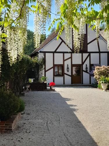 une maison blanche avec un bâtiment noir et blanc dans l'établissement Aux Sources de Ouanne, à Ouanne