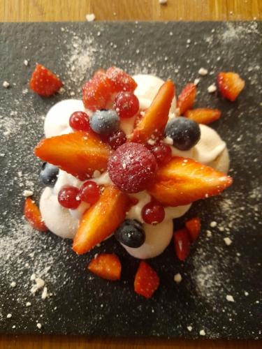 - un dessert avec des fruits, de la crème fouettée et des baies dans l'établissement Aux Sources de Ouanne, à Ouanne
