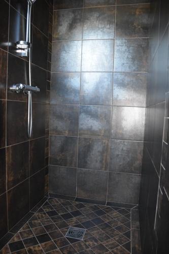 bagno con doccia e parete piastrellata di Gite du Portalet a Bozouls
