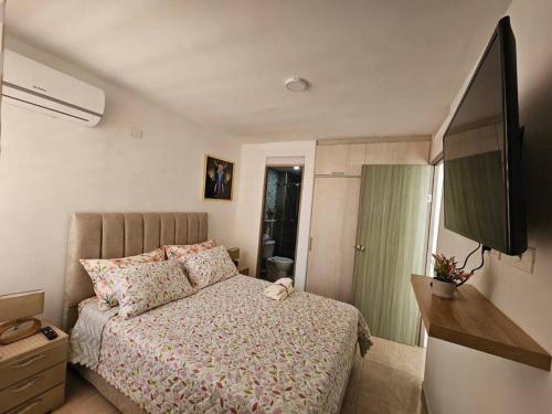 a small bedroom with a bed and a television at Apartamento encanto urbano. in Barranquilla