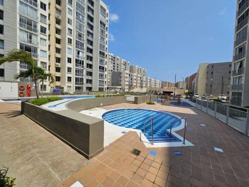 a swimming pool in a city with tall buildings at Apartamento encanto urbano. in Barranquilla