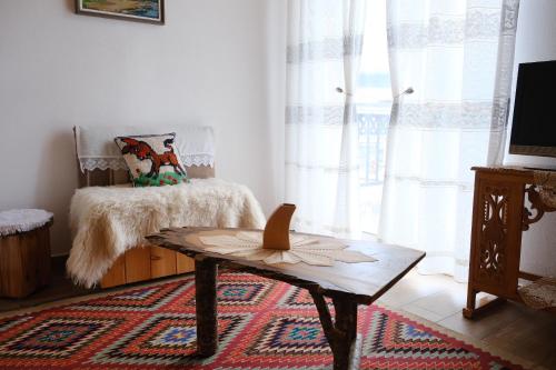 a living room with a coffee table and a window at As e vogël, As e madhe in Ersekë