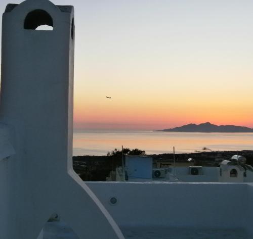 フィラにあるAratos Apartments - Kallisto 2bedroom Apartmentの白い建物からの海上の夕日