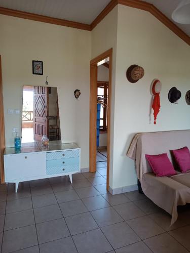 a bedroom with a bed and a dresser with pink pillows at Villa Anta in Skala Kallirachis