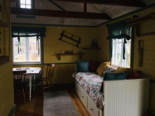 Una habitación con una cama y una mesa en una habitación en Isans stuga, en Broby