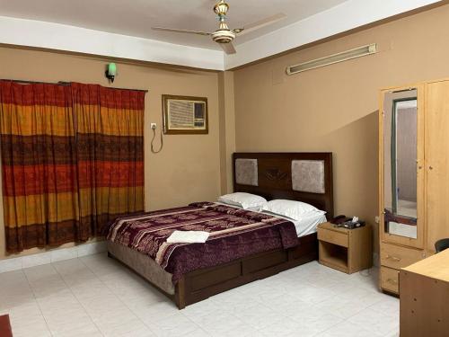a bedroom with a bed and a window at Rainbow Guest House in Sylhet