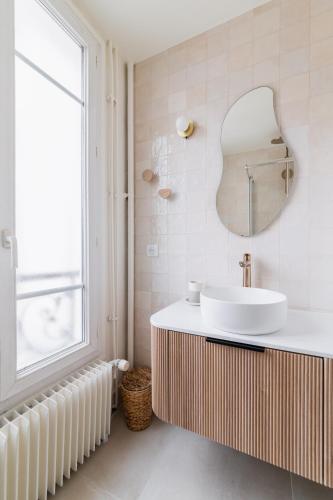 une salle de bain avec un lavabo et un miroir dans l'établissement Brand New Luxury Flat in Parc Monceau - Batignolles, à Paris