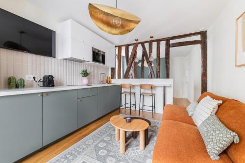 a kitchen and a living room with a couch and a table at Brand New Luxury Flat in Parc Monceau - Batignolles in Paris