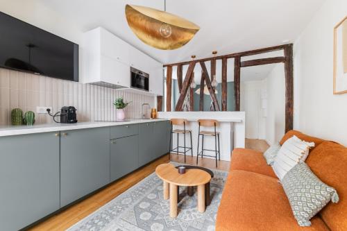 Il dispose d'une cuisine et d'un salon avec un canapé et une table. dans l'établissement Brand New Luxury Flat in Parc Monceau - Batignolles, à Paris