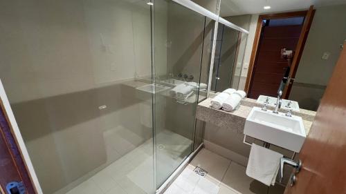 uma casa de banho com uma cabina de duche em vidro e um lavatório. em Loft Lodge - Suíte e Sala em Salvador