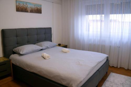 a bedroom with a bed with two towels on it at Triple A Apartments in Sarajevo