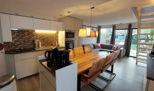 cocina y sala de estar con mesa de comedor de madera en Vakantiehuis Ruby en Bruinisse