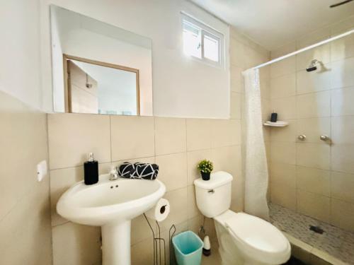 ein Badezimmer mit einem Waschbecken, einem WC und einem Spiegel in der Unterkunft NoMAD House in Guatemala