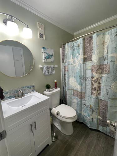 a bathroom with a toilet and a sink and a shower curtain at Bikini Bottom in Carolina Beach