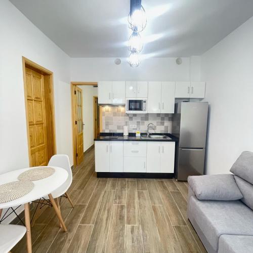 a kitchen and living room with a couch and a table at Bajo Derecha el Wiro in Puerto