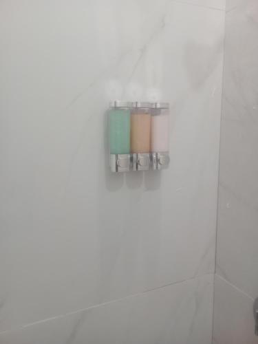 une salle de bains avec un distributeur de savon sur le mur dans l'établissement 7hills comfort suites, à Cooperʼs Town