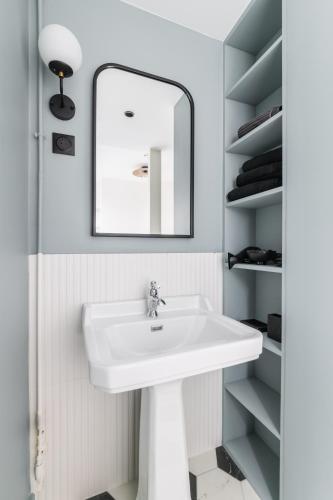 une salle de bain avec un lavabo blanc et un miroir dans l'établissement Brand New Luxury Flat in Champs Elysees - Triangle d'Or, à Paris